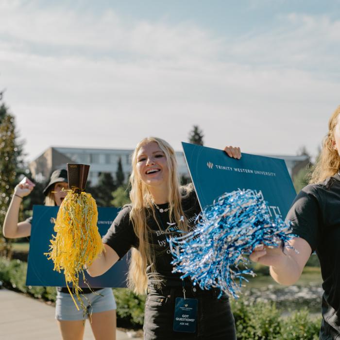 students cheering at orientation for new students near university entrance