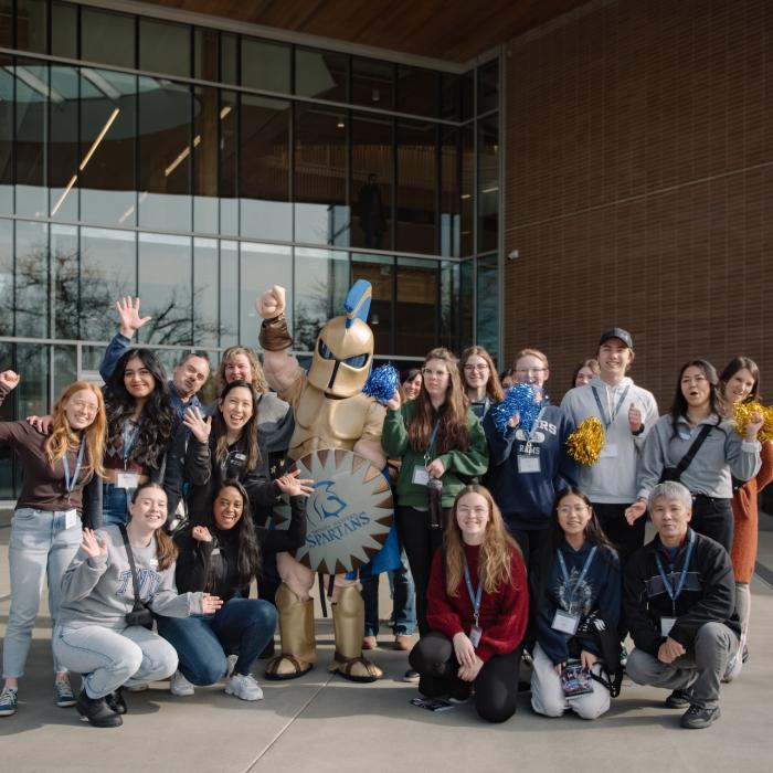 group of people and Sparty posing in front of Kuhn Centre