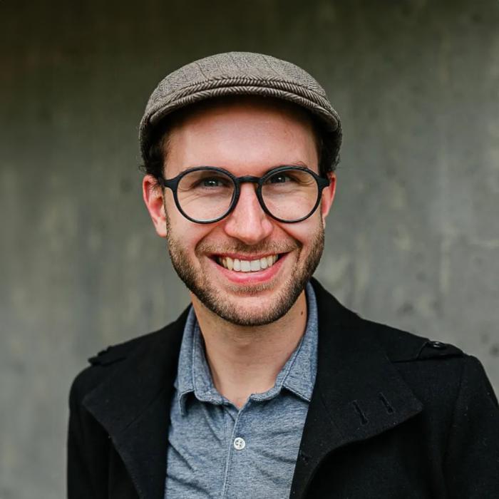 Caleb Wollf standing in front of grey wall