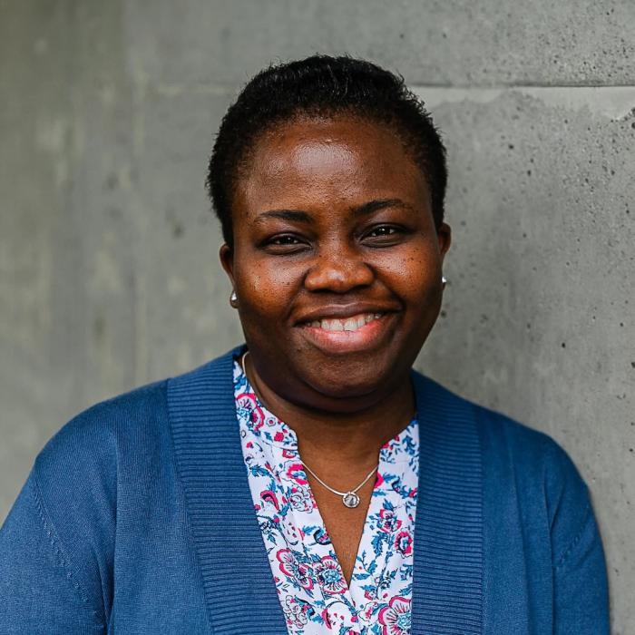 Ifihan Olaoye standing in front of a grey wall