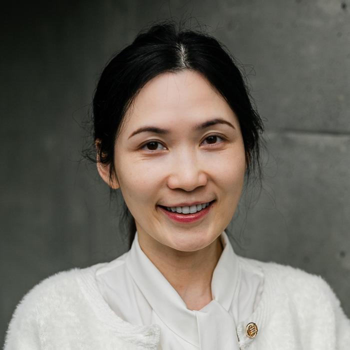 Helen Wang standing in front of grey wall