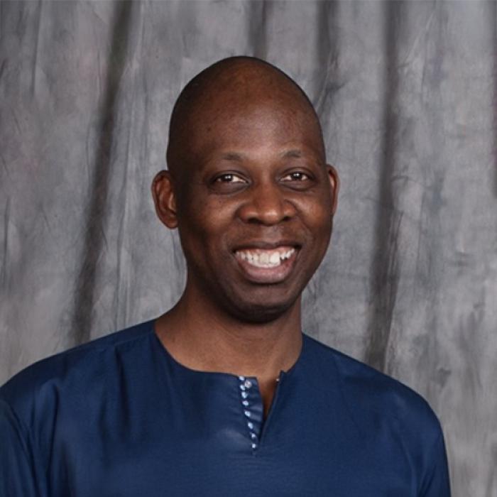 Emmanuel Denguessi standing in front of grey background