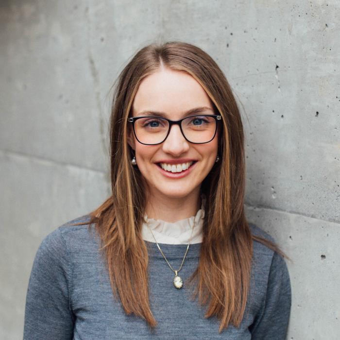 Leah Cameron standing in front of a grey wall