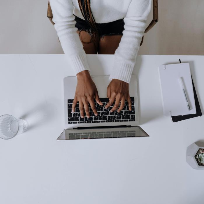 Person typing on a laptop keyboard.