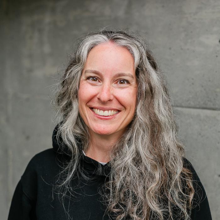 Corinna Werdal standing in front of a grey wall