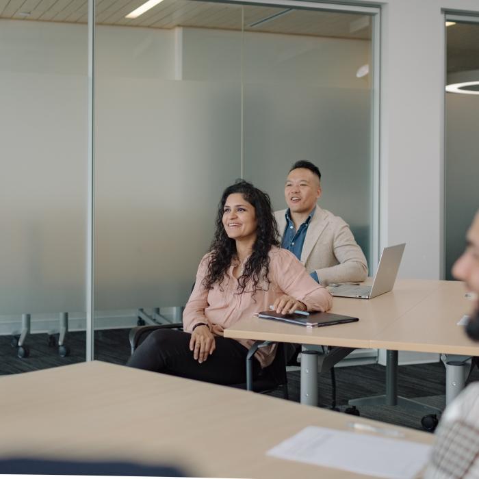 People smiling in a modern conference room.