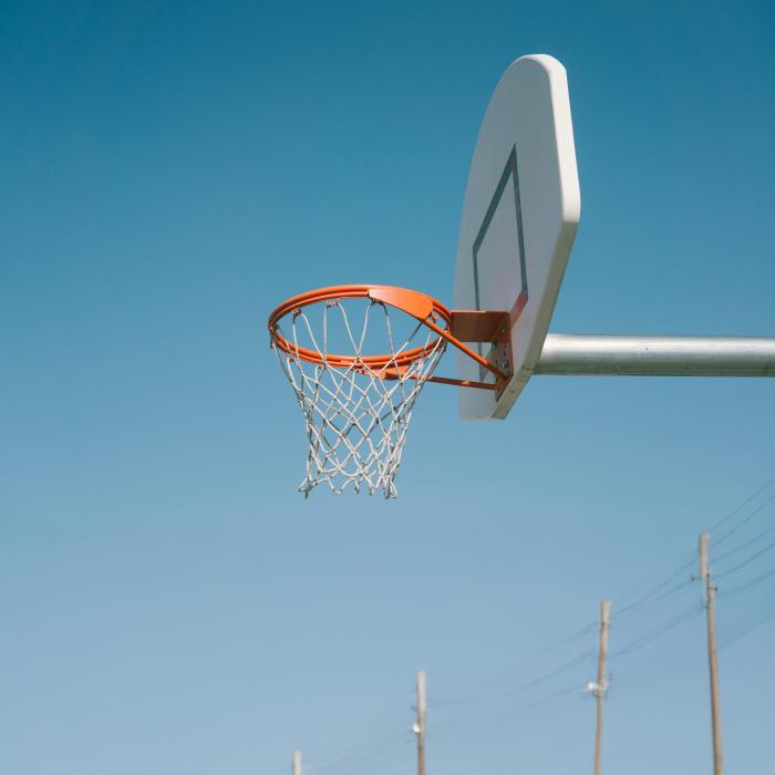 Photograph of basketball hoop with clear blue sky in the background