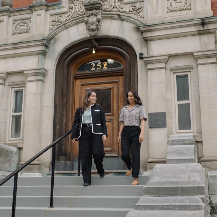 two women walking down the steps of the Laurentian Leadership Centre in business attire