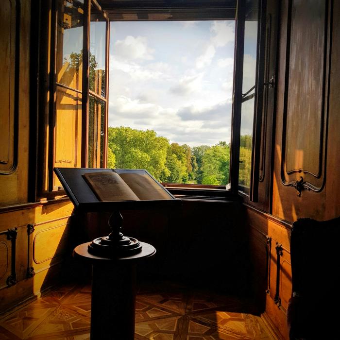 stock photo of book on stand in front of an open window in a grand room