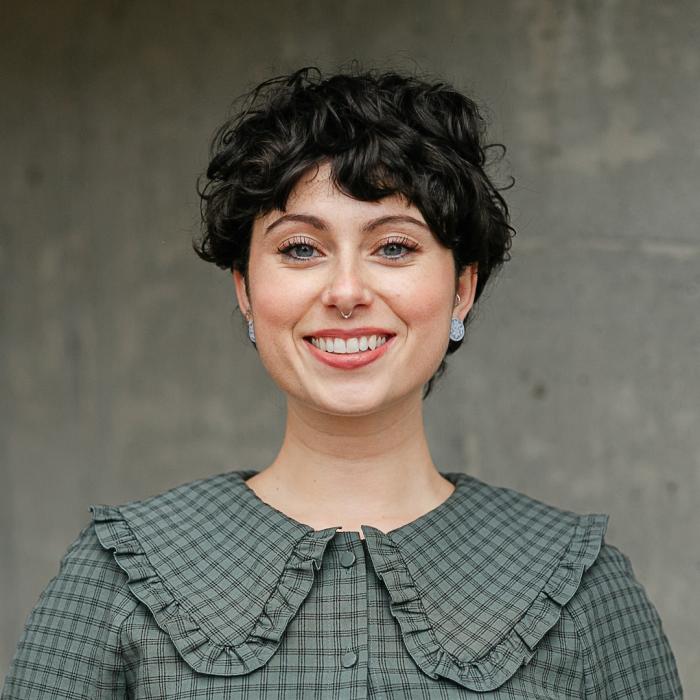 Amanda Nakano standing in front of a grey wall