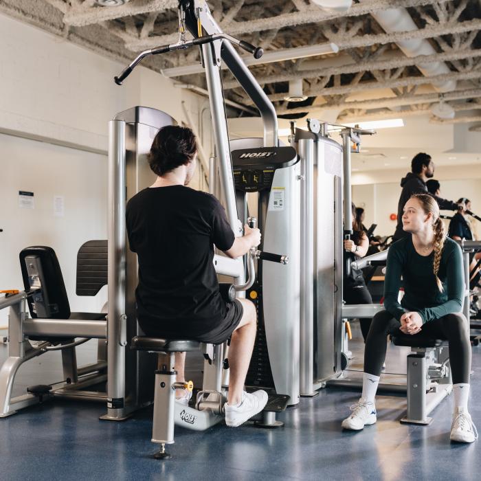 Students using exercise equipment in the fitness centre.