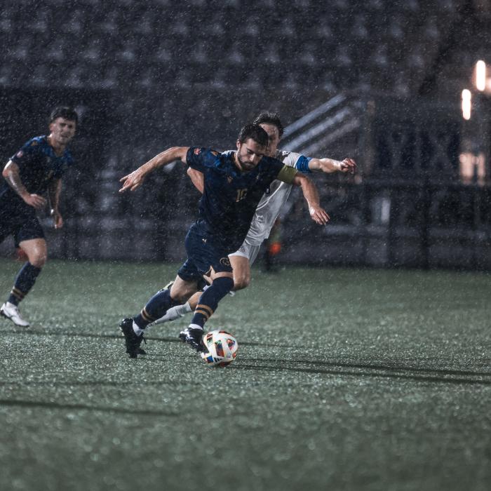 group of men wearing black jersey and playing in the field