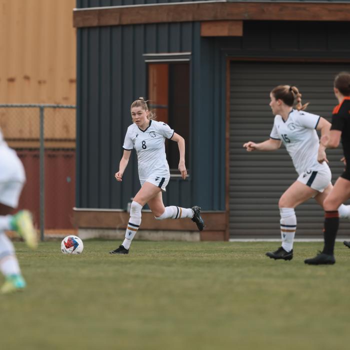 group of women wearing white jersey and playing in the field