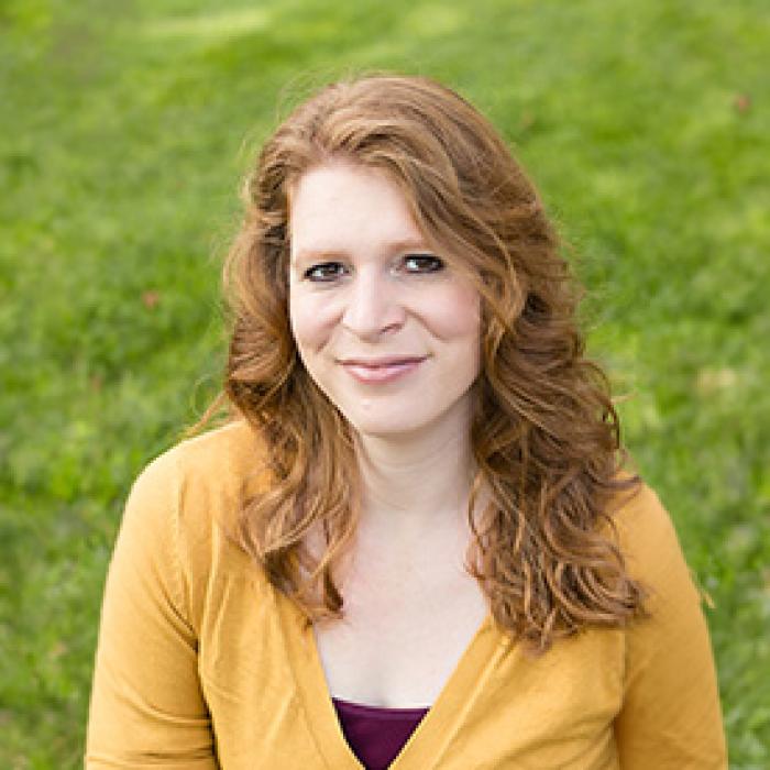 Tracy Stobbe in a yellow shirt in front of green grass
