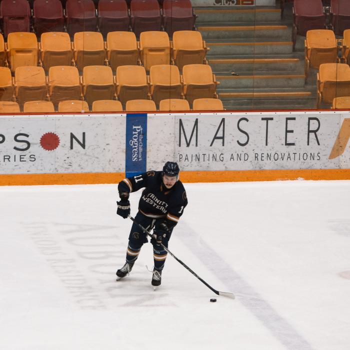 TWU student playing hockey in men's hockey game.