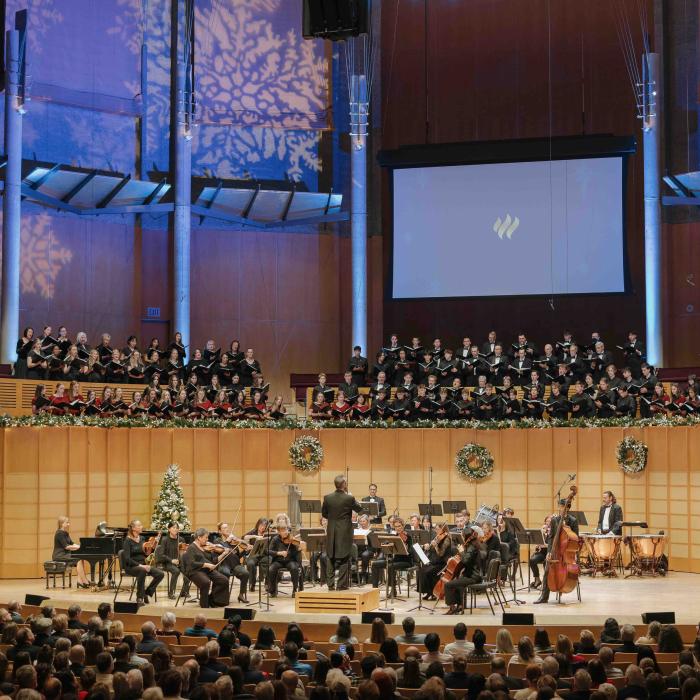 TWU choir and orchestra performing a holiday concert in a packed concert hall.